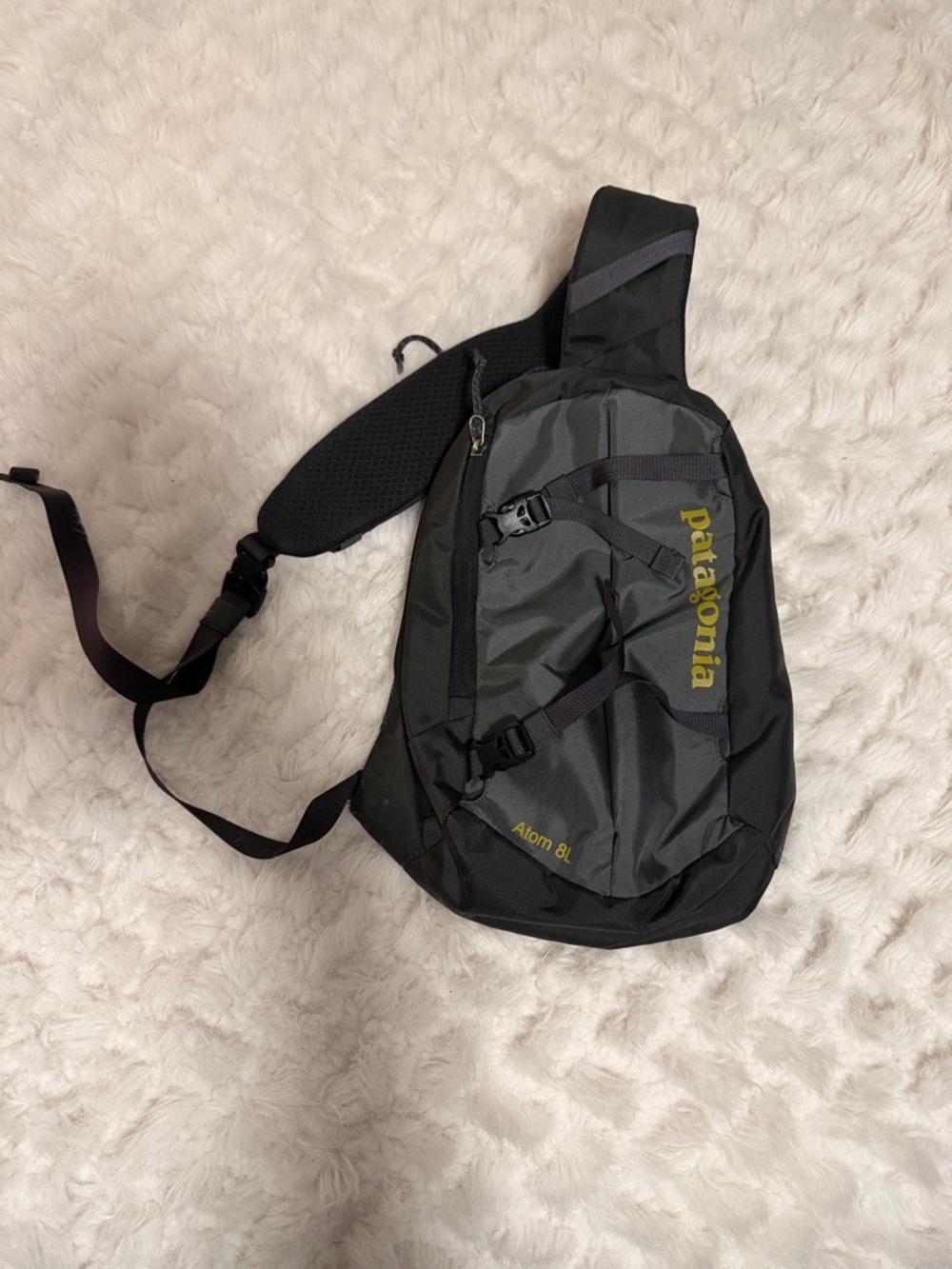Patagonia sling bag in dark gray with olive logo